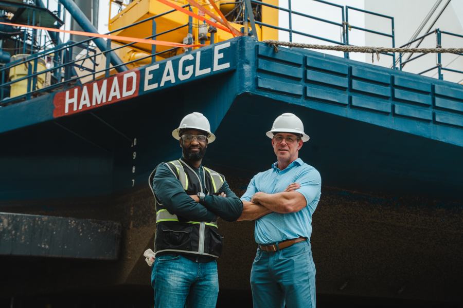 Two crew members in hard hats on deck of the vessel Hamad Eagle